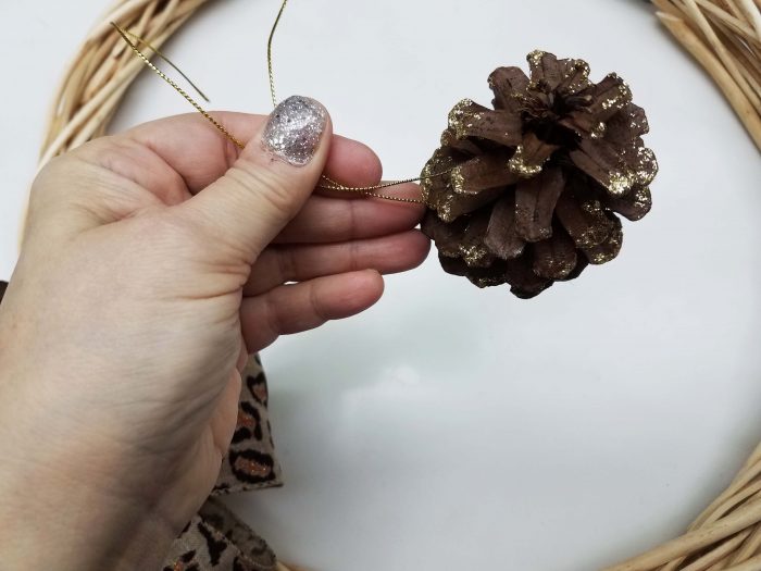 decorating wreath with pine cone