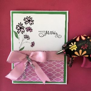 Attach the bow to the front of the Mother's Day card with hot glue