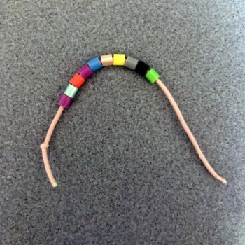 Bracelet Step 1—Tie a Knot in One End and Thread with 10 to 12 Perler Beads