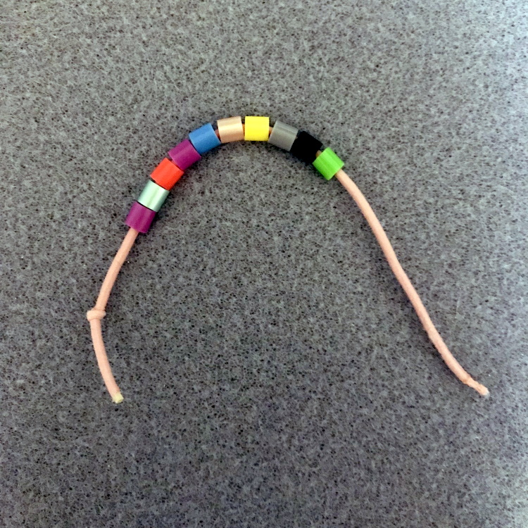 Bracelet Step 1—Tie a Knot in One End and Thread with 10 to 12 Perler Beads
